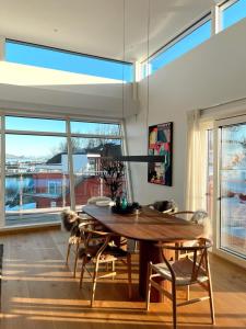 Un comedor con mesa y sillas de madera. en Seaview and private roof top terrace with jacuzzi in Lofoten, en Svolvær