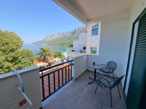 a balcony with chairs and a view of the water at Rooms Katja in Gradac
