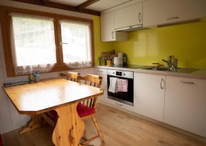 a kitchen with a wooden table and a sink at Chalet Montana mit Bergblick in Brunig +12 photos