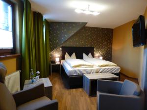 Zum Kronprinzen Hotel Garni في Weyher: غرفه فندقيه بسرير واريكه وكراسي