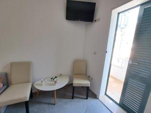 a room with a table and two chairs and a tv at Rooms Katja in Gradac
