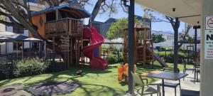 a playground with a slide and a tree house at The Jade Escape in Cape Town