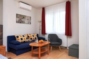 a living room with a blue couch and a table at Apartman Brigitte Bükfürdő in Bük