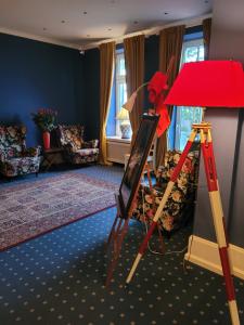 a room with a easel and a red lamp at Hotel Schweriner Hof by ANS in Kühlungsborn