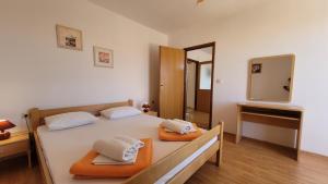 a bedroom with a bed with two towels on it at Apartments Adriana in Omišalj