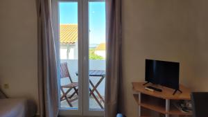 a room with a television on a table with a balcony at Apartments Adriana in Omišalj