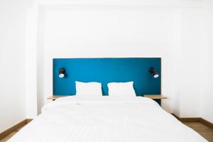 a large white bed with a blue headboard at Smartflats City - Perron in Liège