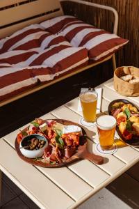 a table with two plates of food and two glasses of beer at Live Hotels Bordeaux Lac in Bordeaux
