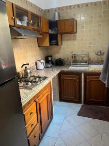 een keuken met houten kasten en een fornuis met oven bij Perfect only family apartment & air cooling in Marrakesh