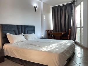 een slaapkamer met een bed, een tafel en een raam bij Perfect only family apartment & air cooling in Marrakesh +10 foto's