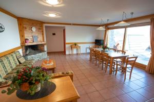 a living room with a couch and a table and chairs at Chalet BOUQUETIN in Oz