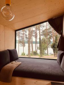 a couch in a room with a large window at Tiny Houses & Schwedenhäuser Ahoi Camp Canow in Wustrow