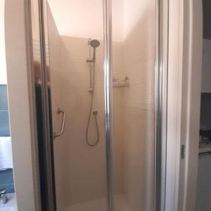 a shower with a glass door in a bathroom at My Comfort Suite in Naples