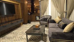 a living room with a couch and a tv at Coral Palace Hotel in Baghdād