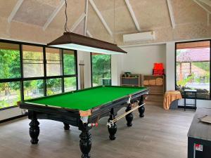 a pool table in a living room with windows at Katiliya Park Villa in Mae Chan +29 photos