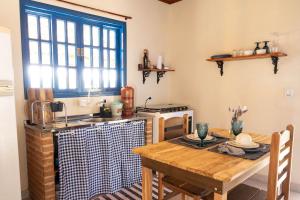 a kitchen with a wooden table and a kitchen with a sink at Recanto da Seriema in Gonçalves