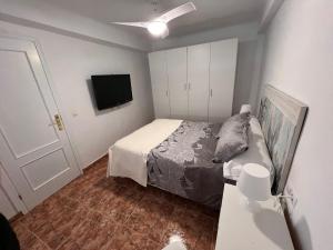 ein Schlafzimmer mit einem Bett und einem Flachbildfernseher in der Unterkunft Apartamento en el centro de Nerja in Nerja