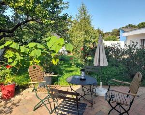 a patio with a table and chairs and an umbrella at Ferienwohnungen Halbturn in Halbturn