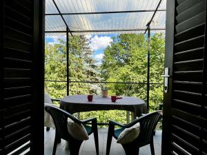 a table and chairs on a porch with a window at Cherry apartman Orfű in Orfű