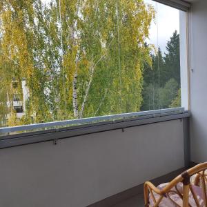 una finestra in una camera con vista sugli alberi di Skandinavisen taiteilijan 2 h huoneisto 2 a Lahti