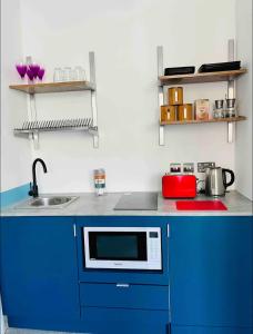 a kitchen with blue cabinets and a sink at 1st 4 Tennants in Portsmouth