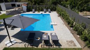 an umbrella and chairs next to a swimming pool at Harmony in Perea