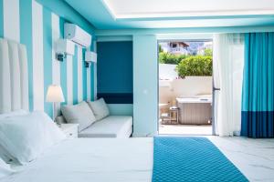 a bedroom with a white bed and a couch at Agios Gordios Beach Resort in Agios Gordios +89 photos