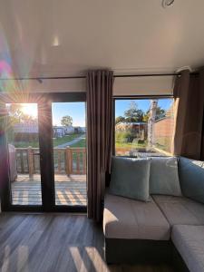 a living room with a couch and a sliding glass door at Chalet Pampusplaat 16 in Lauwersoog +46 photos