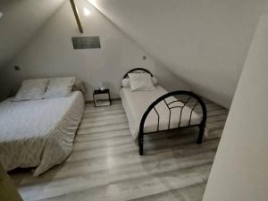 a attic bedroom with two beds and a staircase at maison luxe césar aeroport tillé 2 a 7 personnes in Tillé