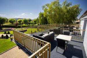 a balcony with a wooden fence and a table and chairs at Hotel Conde Rodrigo II by eme hoteles in Ciudad-Rodrigo