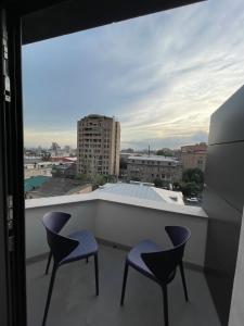 a balcony with two chairs and a view of a city at Aygestan plaza apartment 5 in Yerevan