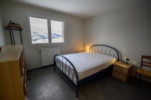 Un dormitorio pequeño con una cama y una ventana. en chalet Les Aplanes appt, en Albiez-Montrond