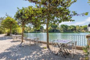 a row of tables and chairs next to a lake at Village Pierre & Vacances Pont Royal en Provence in Mallemort