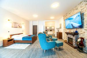 a bedroom with a bed and a tv on a brick wall at Joy Studio - Poiana Brasov - Silver Resort in Poiana Brasov