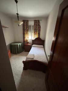 a small bedroom with a bed and a window at Piso completo, acogedor y cerca del centro in Baeza