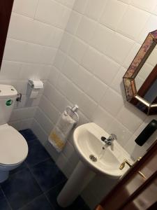 a bathroom with a white sink and a toilet at Piso completo, acogedor y cerca del centro in Baeza