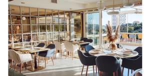 a dining room with tables and chairs and windows at Status-M Аpartments 173 in Bečići