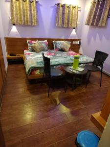 a bedroom with a bed and chairs and a table at Shaleen Elegance Homestay Near Nakki Lake in Mount Ābu