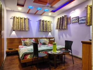a room with a bed and a table and chairs at Shaleen Elegance Homestay Near Nakki Lake in Mount Ābu