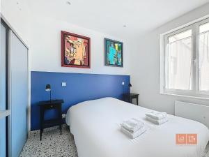 - une chambre bleue et blanche avec un lit et une fenêtre dans l'établissement Les Lutins - sur la plage, à Wimereux