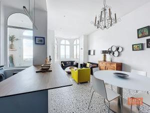 un salon avec une table et une chaise jaune dans l'établissement Les Lutins - sur la plage, à Wimereux 7 autres photos