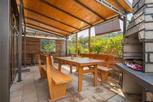 un patio con tavolo e sedie in legno di Apartments Natura a Adlešiči