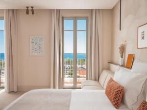a bedroom with a bed and a view of the ocean at Hôtel Liautaud Rooftop Cassis in Cassis