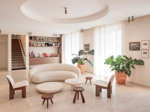 a living room with a white couch and tables at Hôtel Liautaud Rooftop Cassis in Cassis