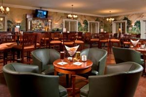 a restaurant with tables and chairs and a bar at Gideon Putnam Resort & Spa in Saratoga Springs