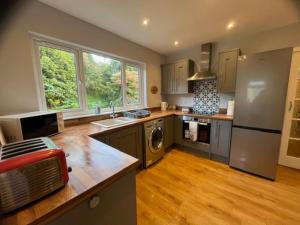 a large kitchen with a sink and a refrigerator at Lademill Cottage in Aberfeldy