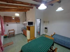 a living room with a table and a kitchen at Abi in Esquel