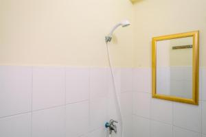 a bathroom with a shower with a mirror at Comfort and Cozy Living 2BR at Cibubur Village Apartment By Travelio in Depok +6 photos