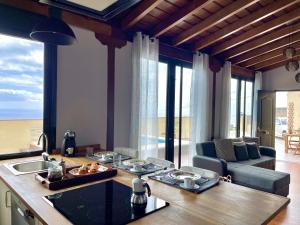 a kitchen and living room with a view of the ocean at Casa Musiú: vistas únicas y excelente ubicación! in Las Nieves