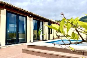 a house with glass windows and a swimming pool at Casa Musiú: vistas únicas y excelente ubicación! in Las Nieves